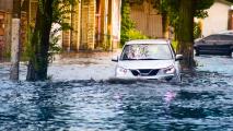 A car driving through a flooded street.