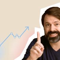 A man with a beard is pointing at a graph.