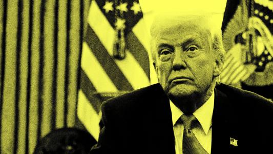 A man in a suit sits in a room with American flags behind him. The image is in high contrast with a yellow tint.